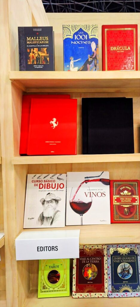 Stand de la editorial Editors en una feria del libro con estanterías de madera y libros expuestos